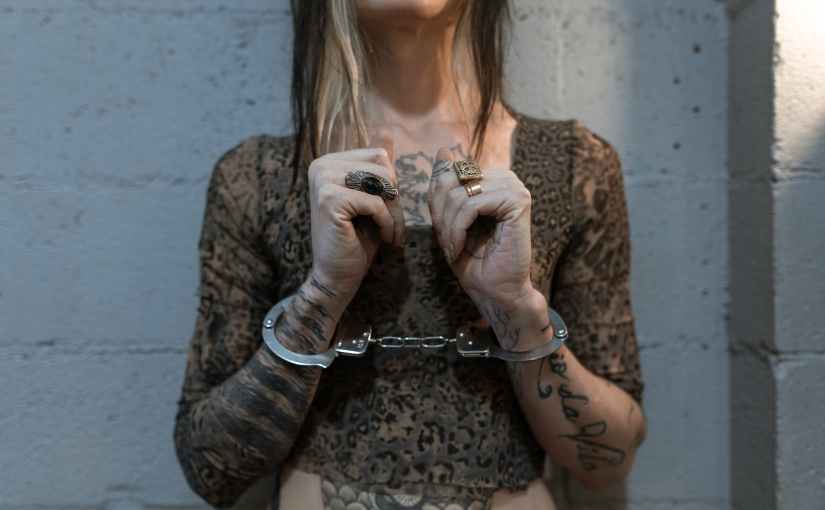 a woman with tattoo with handcuffs