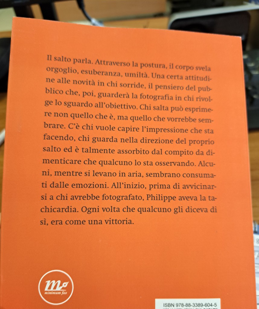 Retro di un libro con testo arancione che parla del concetto di salto, descrivendo emozioni come orgoglio ed esuberanza, e l'esperienza di chi salta.