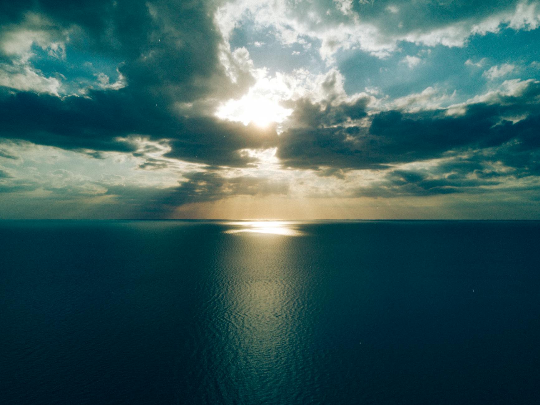 ocean under crepuscular clouds