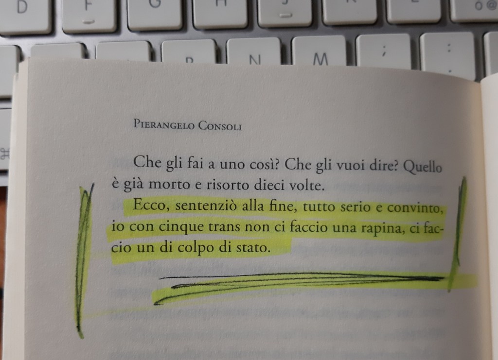 Pagina di un libro di Pierangelo Consoli con testo evidenziato in giallo, posizionata su un tavolo vicino a una tastiera.