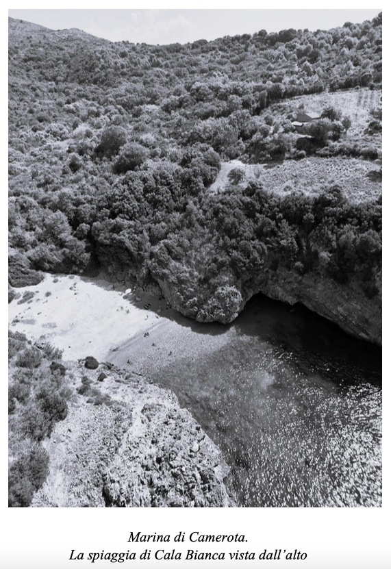 Panorama aereo della spiaggia di Cala Bianca a Marina di Camerota, circondata da vegetazione lussureggiante.