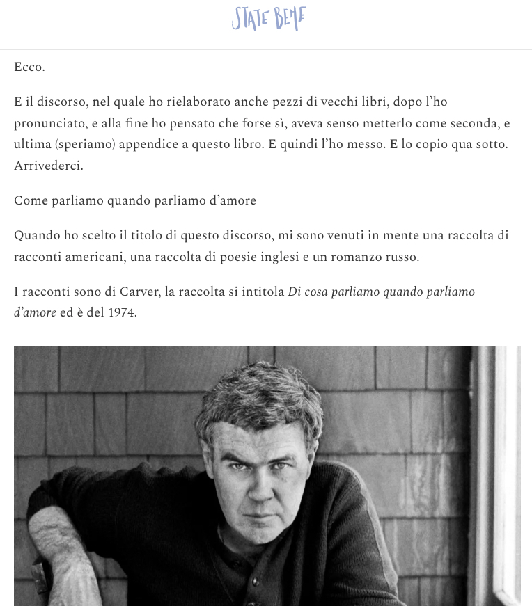 Ritratto in bianco e nero di un uomo con capelli grigi, seduto con le braccia incrociate su una superficie di legno, mentre guarda dritto verso la fotocamera.