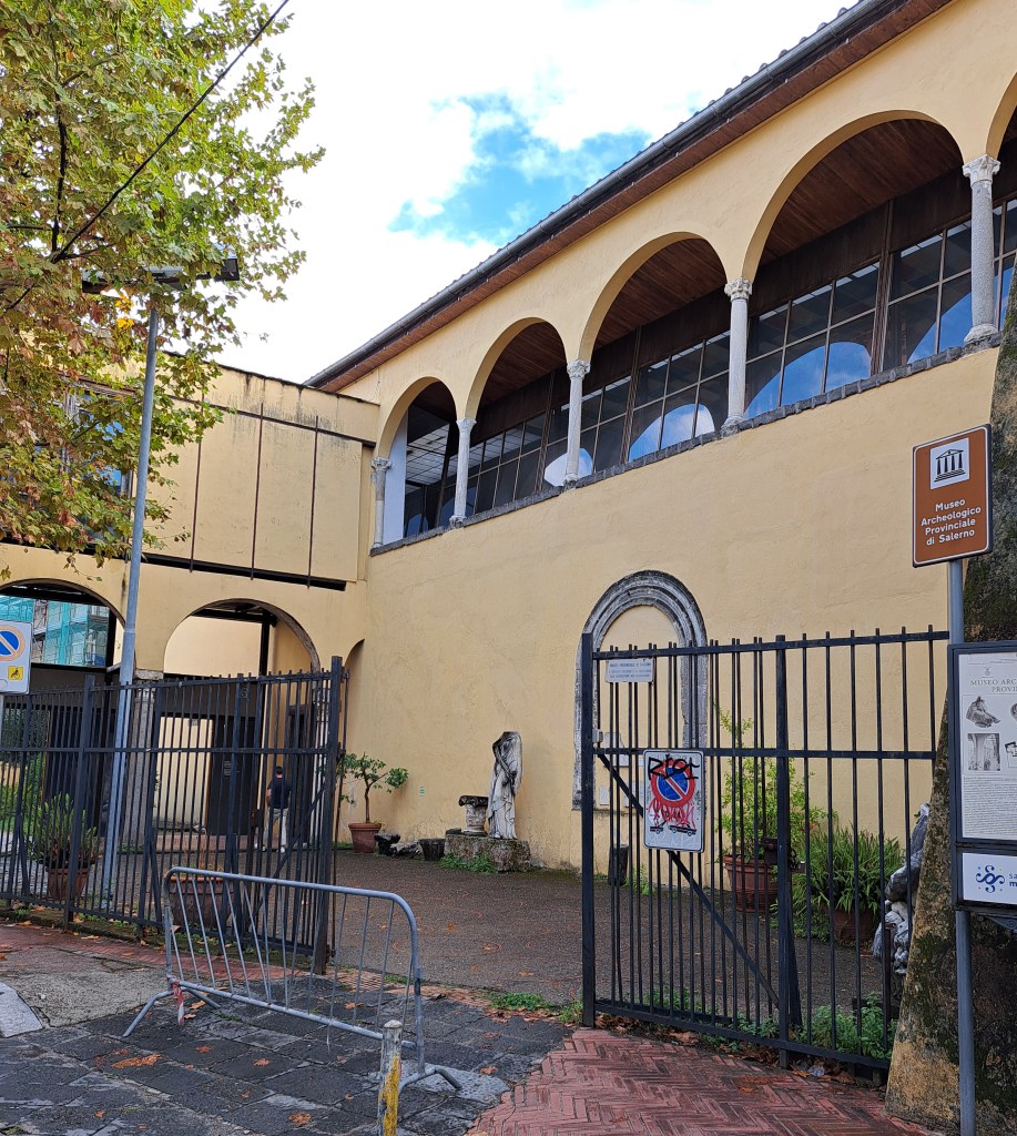 Facciata del Museo Archeologico Provinciale di Salerno, con finestre ad arco e una statua visibile attraverso il cancello.