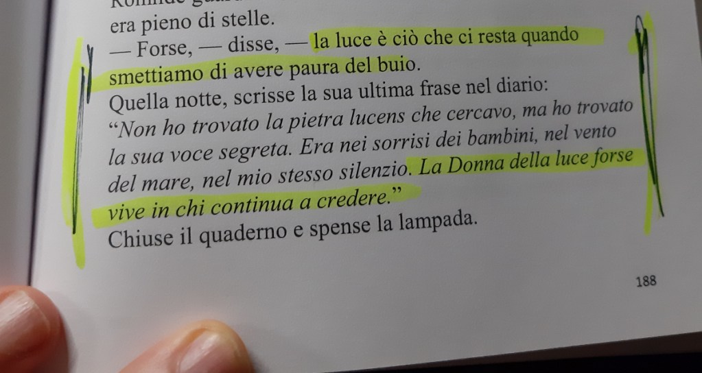 A page from a book featuring highlighted text discussing themes of light and hope, with a hand partially visible holding the page.