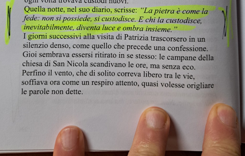 Un passaggio da un romanzo, con testo evidenziato, scritto a mano, su una pagina di libro. La parte inferiore mostra un paio di mani che tengono la pagina.