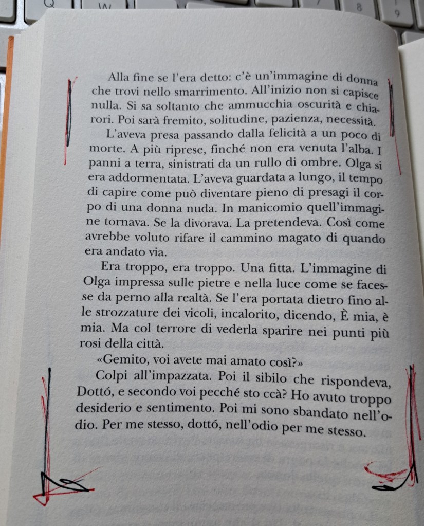 Pagina di un libro scritto in italiano, contenente un testo narrativo. Sono presenti annotazioni e segni di evidenziazione in rosso. Sullo sfondo, si intravede una tastiera.
